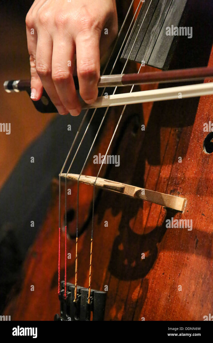 Close up violoncellista con le mani in mano e la prua mentre suona un violoncello Foto Stock