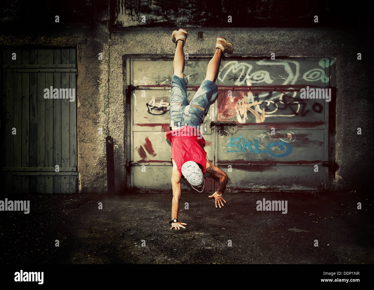 Giovane uomo / teen ballare su grunge graffiti sullo sfondo della parete Foto Stock