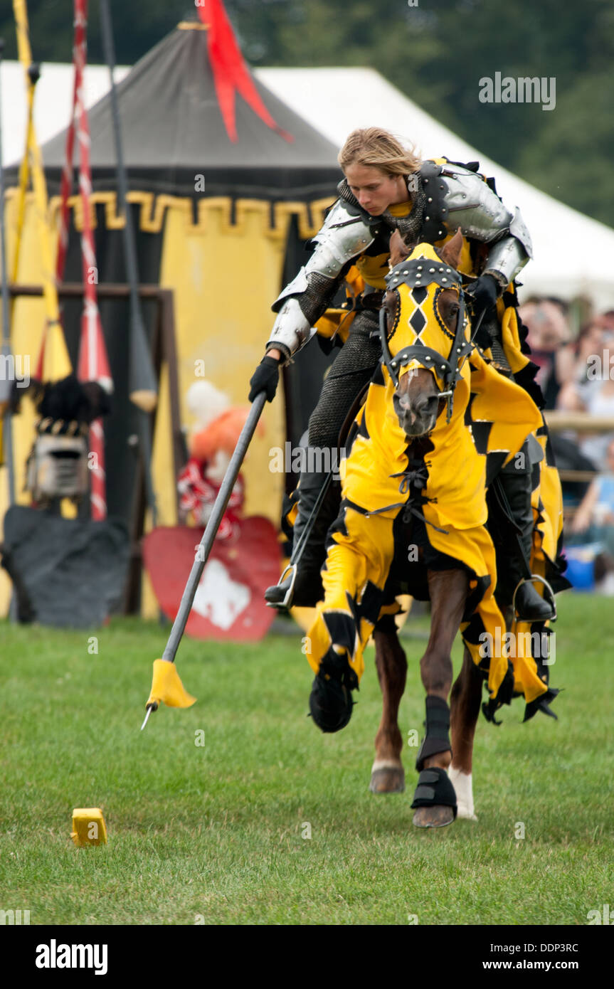 Un cavaliere e cavallo in abito medievale dimostrando al galoppo e ancoraggio al medioevale rievocazione evento torneo nel Regno Unito Foto Stock