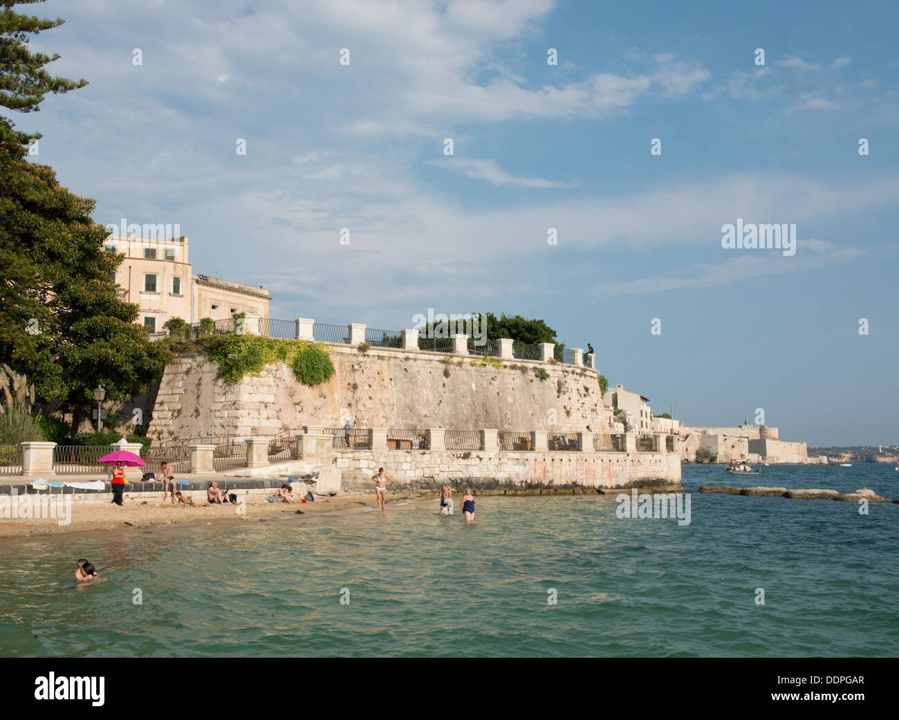 Nuotatori in corrispondenza di una piccola spiaggia su Ortigia a Siracusa, Sicilia, Italia Foto Stock