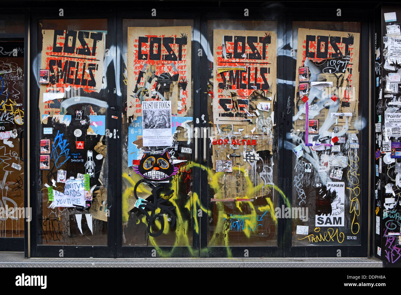 Un muro su un ristorante chiuso a Williamsburg, Brooklyn, New York con graffiti , tag, poster strappati e adesivi. Foto Stock