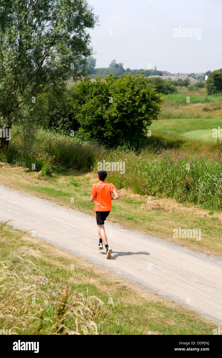 Uomo che corre lungo il millennio sentiero costiero, Machynys, Llanelli, Carmarthenshire, West Wales. Foto Stock