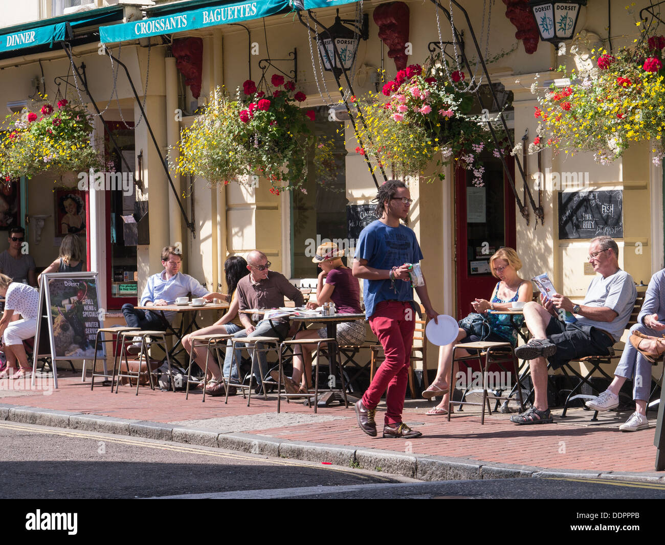 Persone sedersi in un bar al sole in North Laine, Brighton, Regno Unito Foto Stock