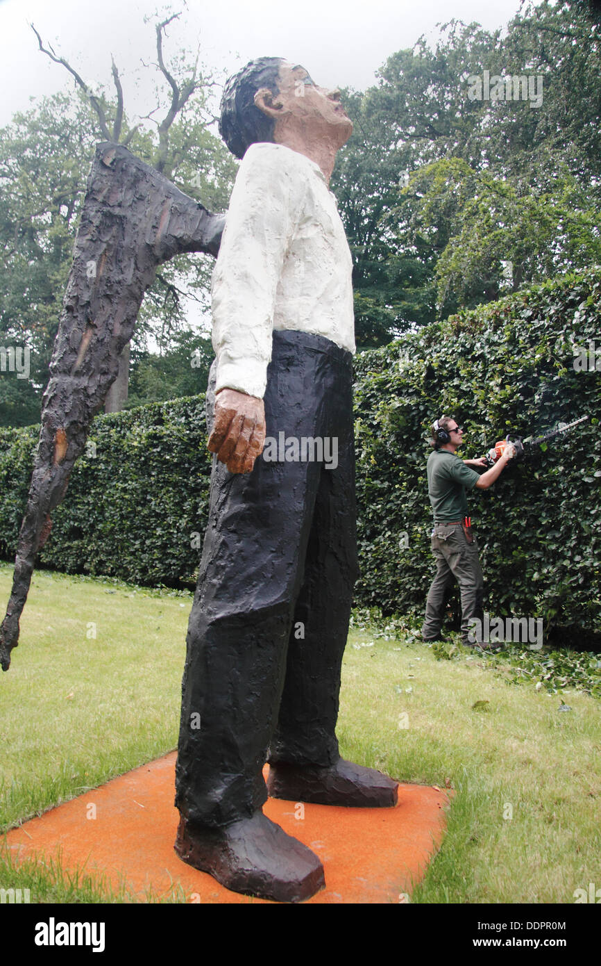 Il 5 settembre 2013. Il Peak District, Derbyshire, Regno Unito. Premere il tasto di chiamata: Chatsworth giardiniere, Rowan Tuffrey forme il faggio avenue accanto a Stephan Balkenhol il bronzo dipinto 'Engel' prima del lancio di Sotheby's al di là dei limiti della scultura monumentale salone di vendita, Chatsworth House. Al di là dei limiti comprende più di 20 sculture monumentali in ChatsworthÕs 105 acri di giardini da artisti internazionali come ad esempio Allen Jones, Jaume da Plensa a & Bosco Sodi. Al di là dei limiti corre 9 sett-27 Ott, 11am-6pm ogni giorno senza alcun costo aggiuntivo oltre il giardino normale ammissione Foto Stock