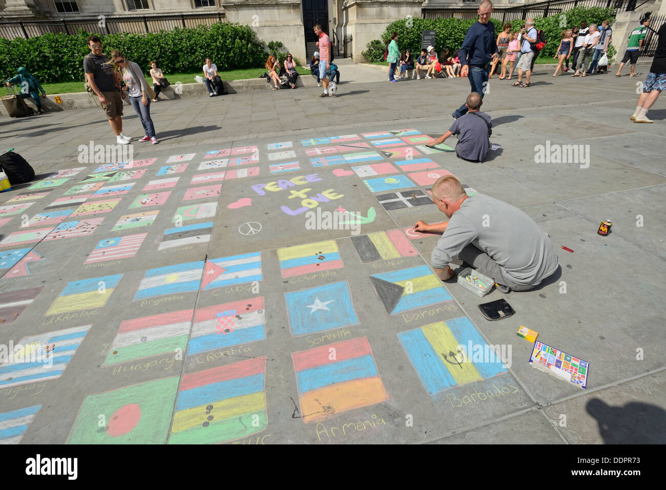 Artista di strada che disegna bandiere nazionali a Trafalgar Square, Londra, Regno Unito Foto Stock