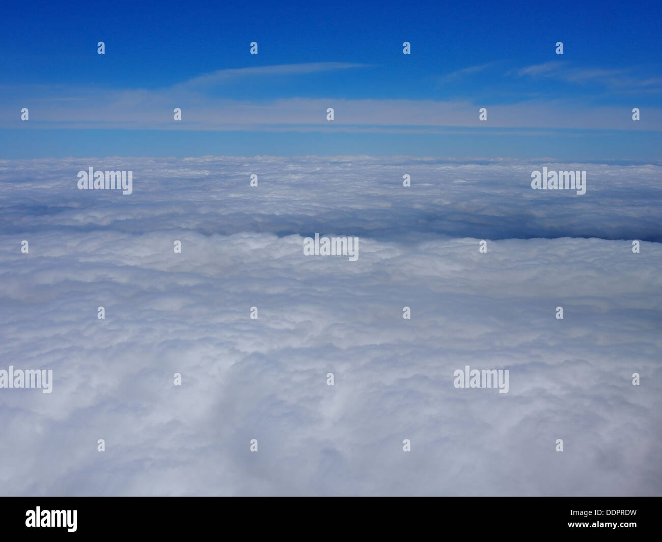 Cielo blu sopra e nuvole bianche di seguito, presa da un aereo ad alta quota. Foto Stock