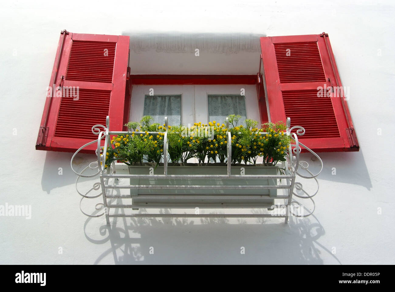 Vintage finestra rossa sul muro bianco e cesto di fiori. Foto Stock