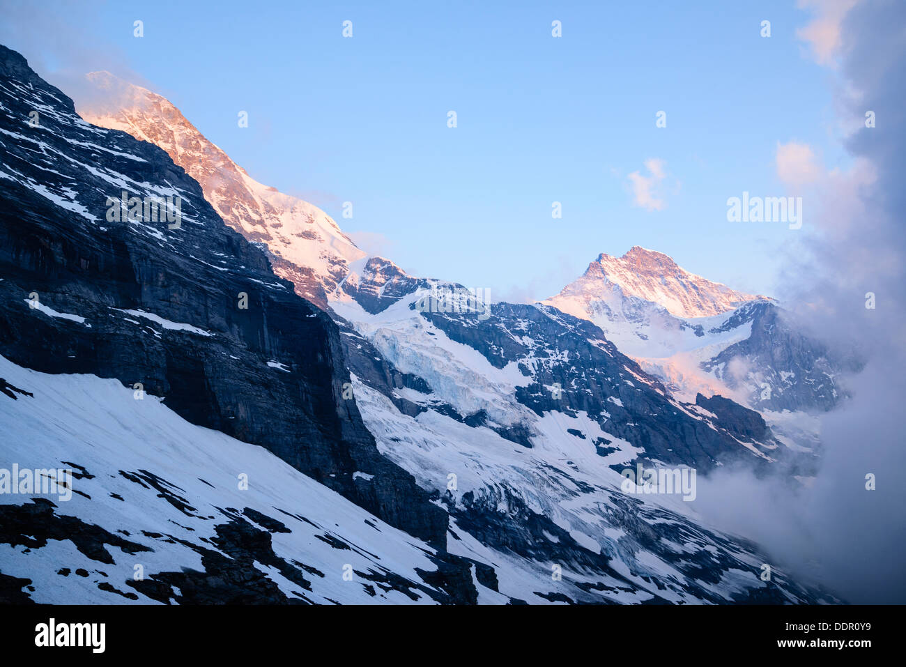 Luce della Sera e la nebbia sul 4197m Monch (sinistra) e 4158m Jungfrau dal Rotstock nelle Alpi svizzere nei pressi di Grindelwald Foto Stock