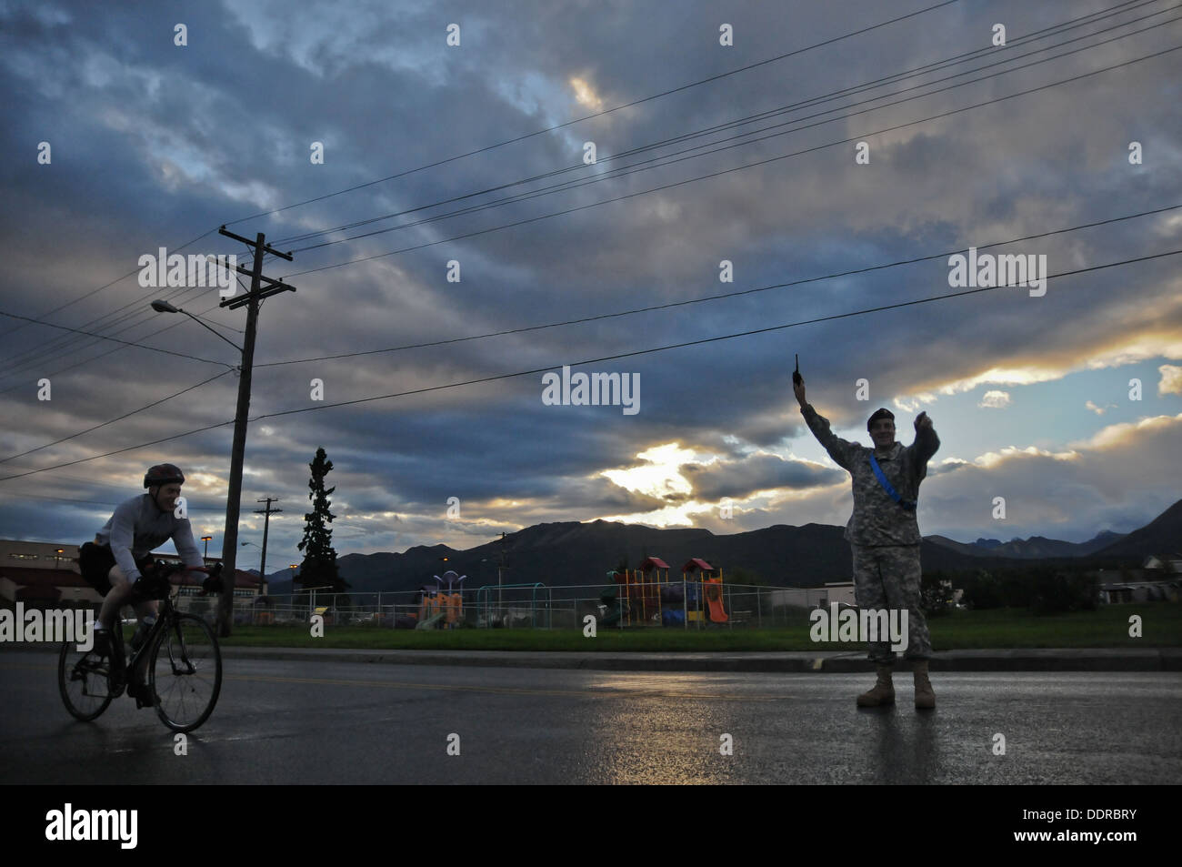 Stati Uniti Esercito il Mag. Dale Papka con sede società, quarta brigata di fanteria combattere Team (airborne), XXV divisione di fanteria, dirige il traffico come un paracadutista Spartan attraversa la linea del traguardo dopo il completamento di un 17-Mile bike race per iniziare Sparta settimana qui a Foto Stock