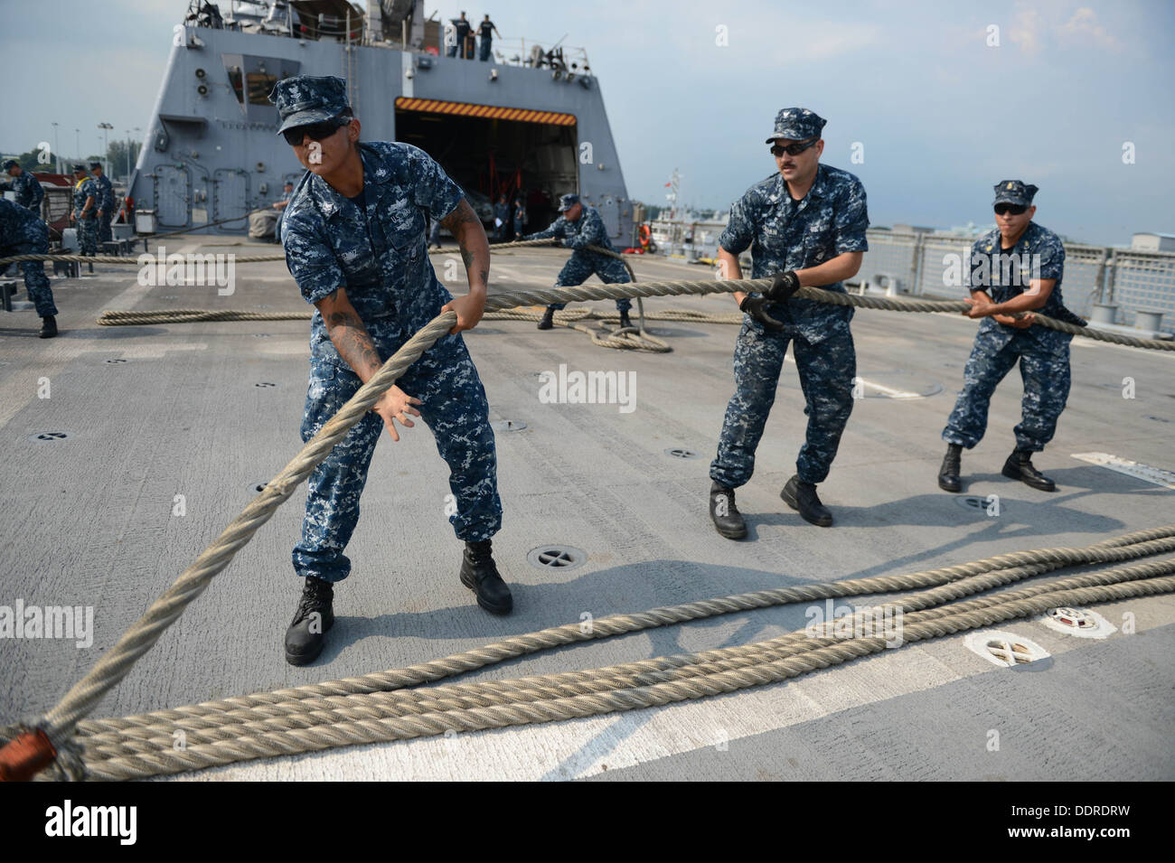 I marinai a bordo del Littoral Combat Ship USS libertà (LCS 1) heave in una linea durante un mare e dettaglio di ancoraggio come la libertà si prepara Foto Stock
