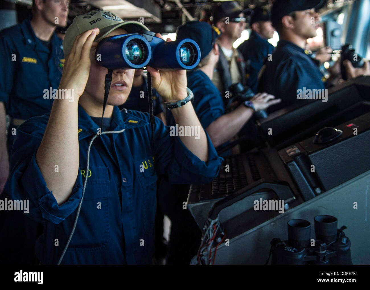 Alfiere Jane Baird osserva i contatti di superficie dal ponte di visite-missile destroyer USS Higgins (DDG 76) come la nave tira Foto Stock