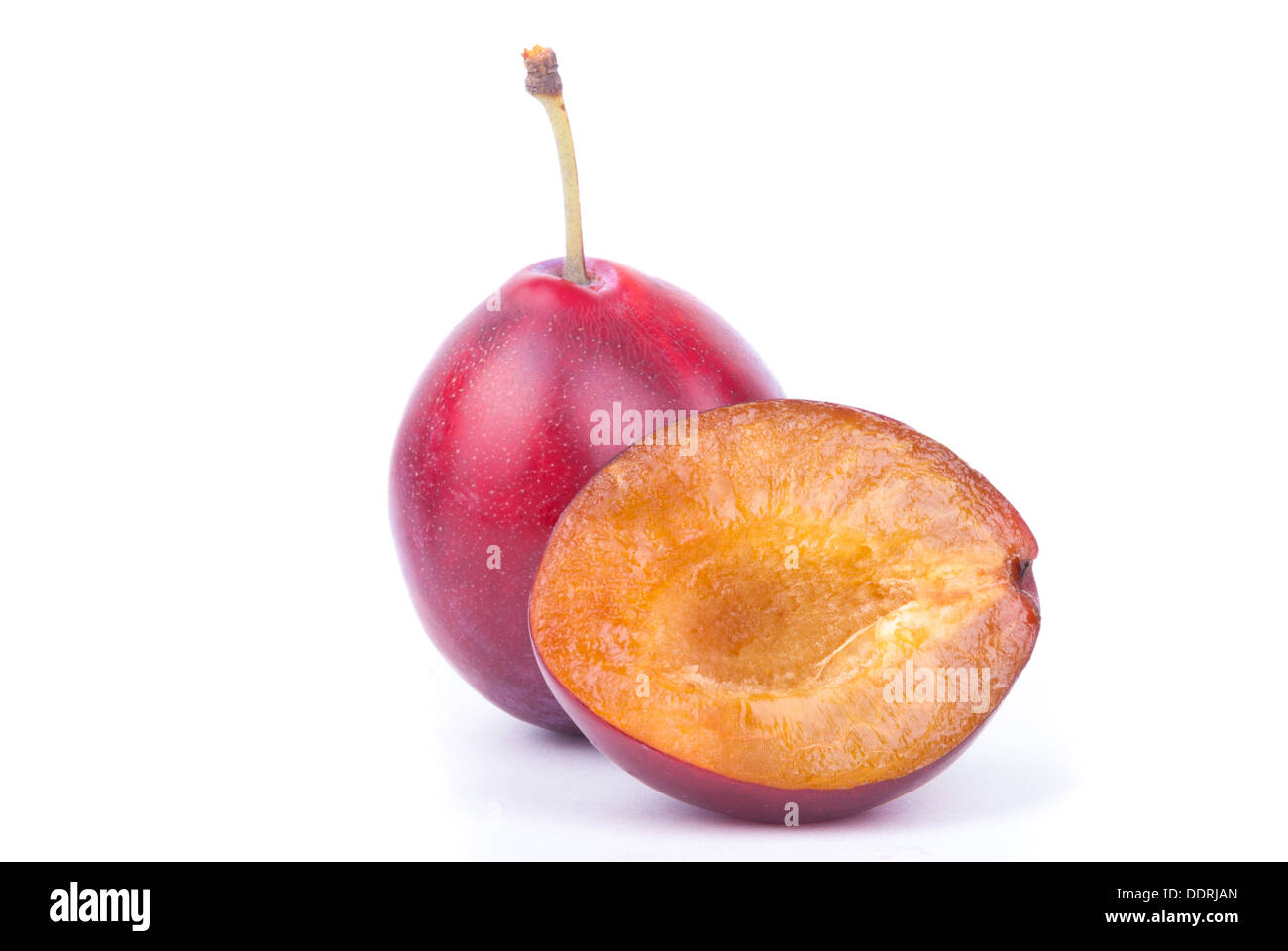 Intero e affettato ​​plums isolato su uno sfondo bianco. Foto Stock