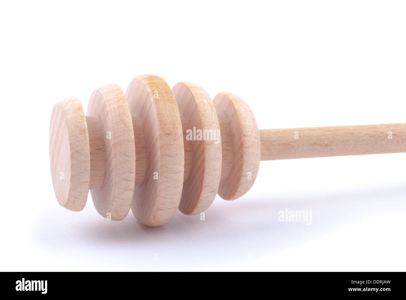 Cucchiaio di legno per il miele su uno sfondo bianco. Foto Stock