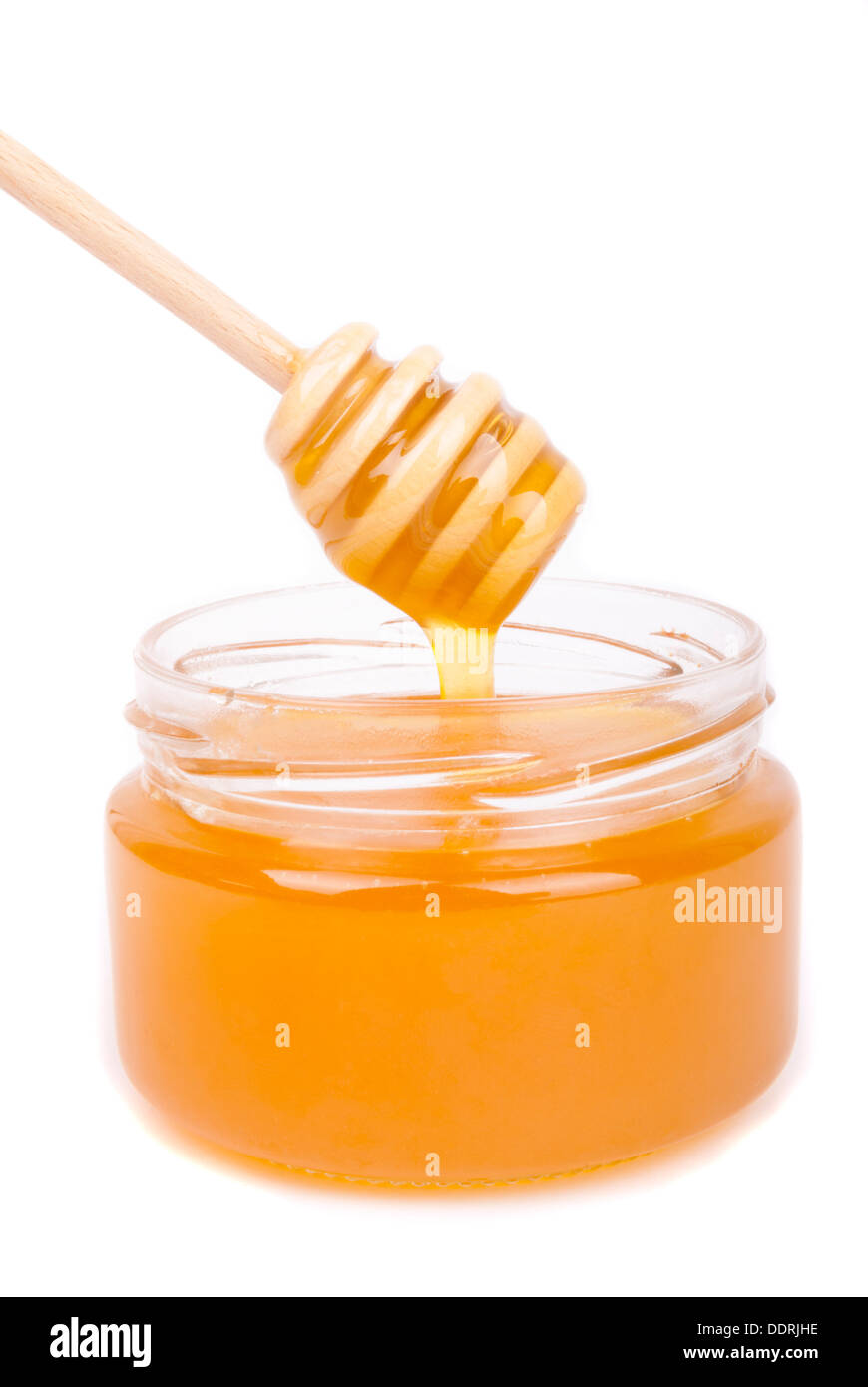 Il miele gocciolamento in un vaso con un cucchiaio speciale. Foto Stock