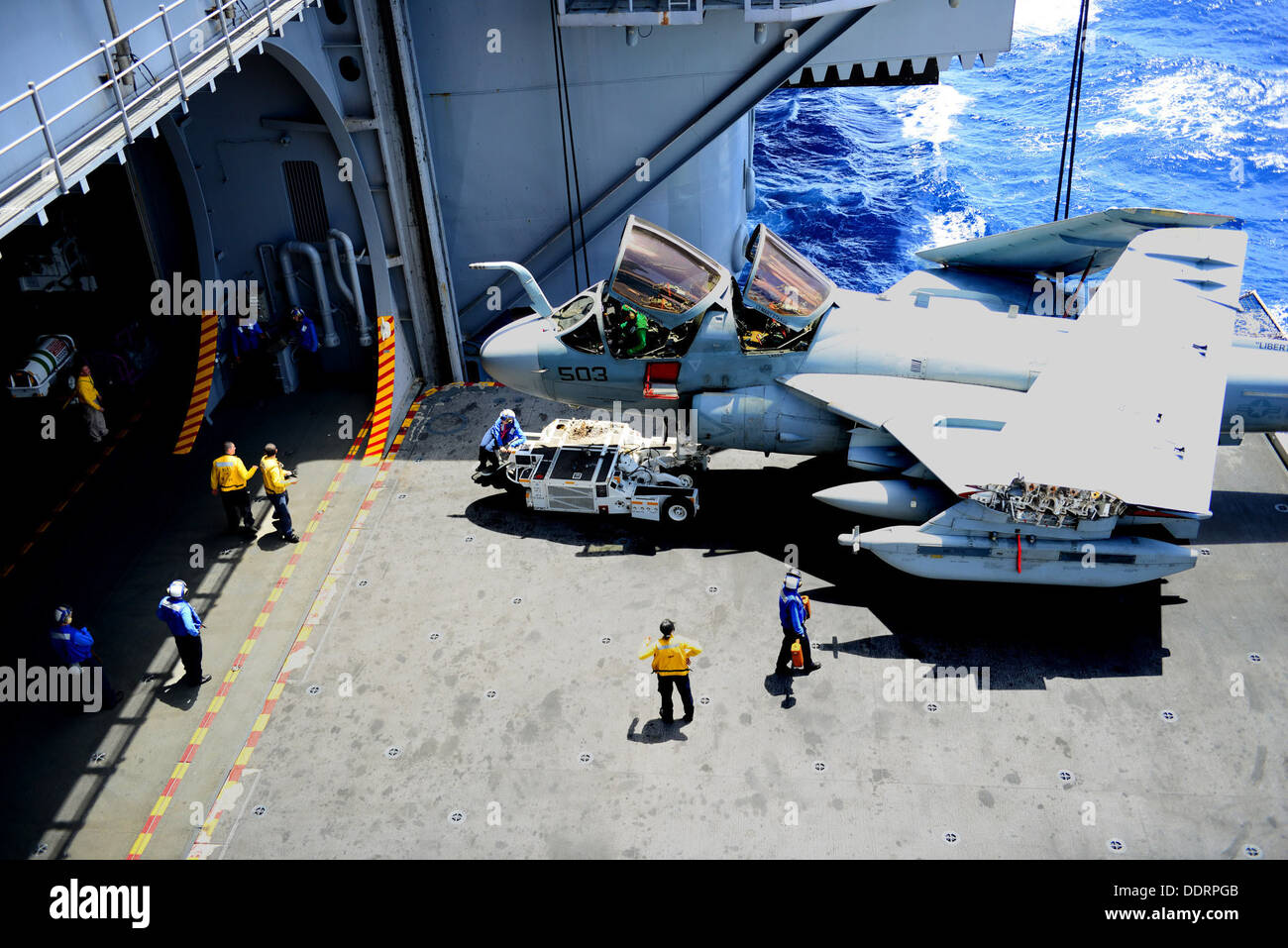 Stati Uniti I marinai spostare un EA-6B Prowler aeromobile assegnati per attacco elettronico Squadron (VAQ) 141 nell'hangar bay a bordo della portaerei USS George H.W. Bussola (CVN 77) nell'Oceano Atlantico Agosto 8, 2013. Il George H.W. Bush stava conducendo su misura shi Foto Stock