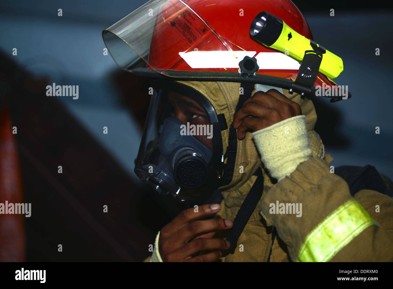 Stati Uniti Navy specialista del personale di terza classe Tinsely Dominque dons le attrezzature antincendio per un quartier generale (GQ) praticare a bordo Foto Stock