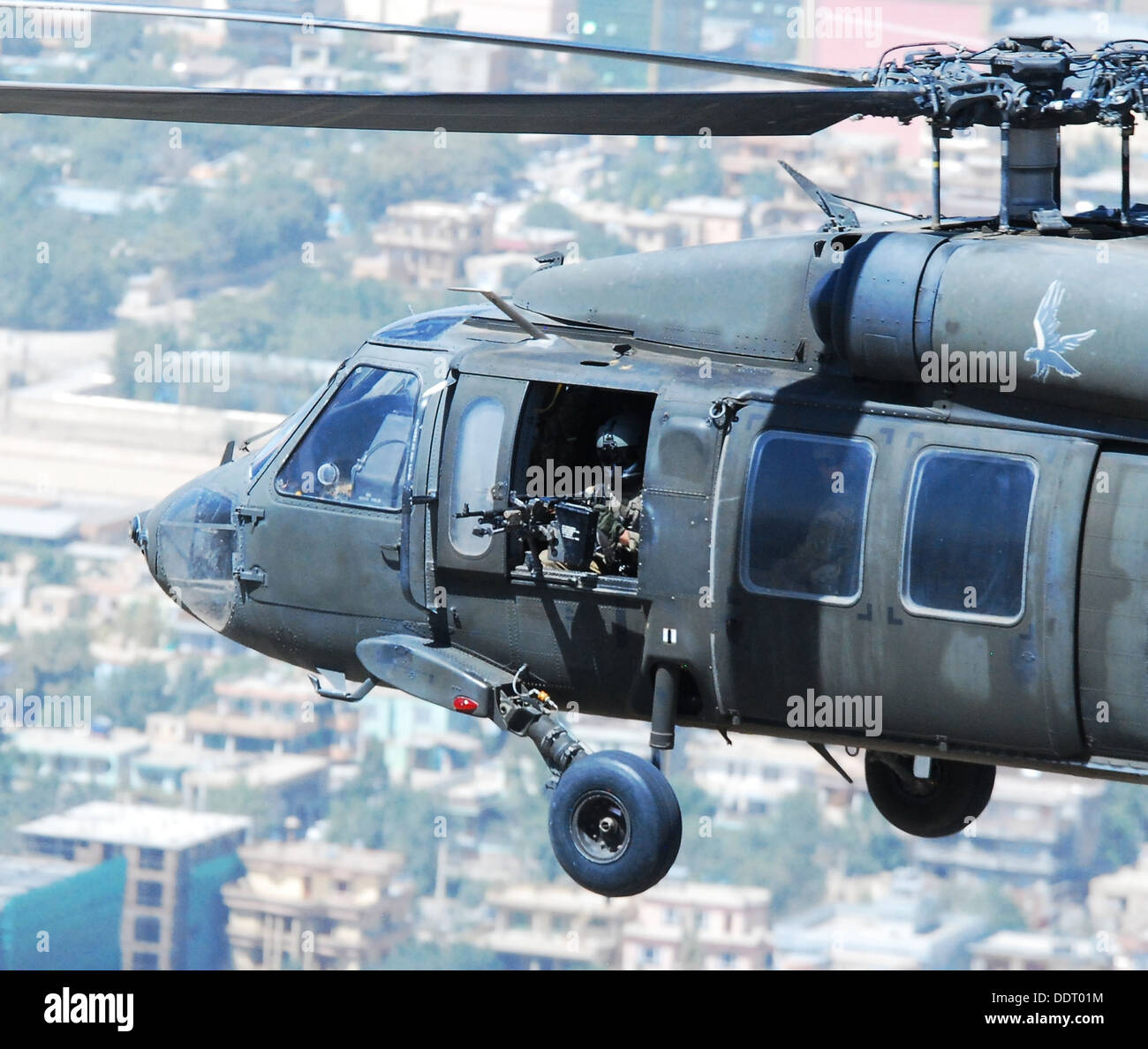 Sgt. Jay aringa, un UH-60 Black Hawk elicottero capo equipaggio assegnati a una società, secondo battaglione (supporto generale), 104th reggimento di aviazione (Pennsylvania National Guard), Task Force Phoenix, scandisce il suo settore di fuoco mentre effettua un approccio in un atterraggio Foto Stock