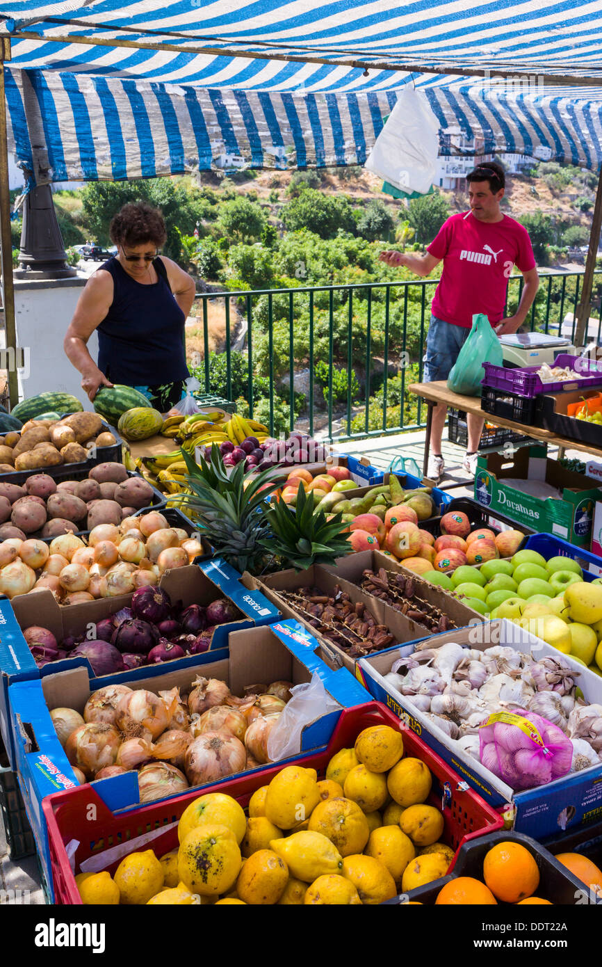 Una signora si ammira il produrre in un mercato locale in stallo a Frigiliana, Andalusia - Spagna. Foto Stock