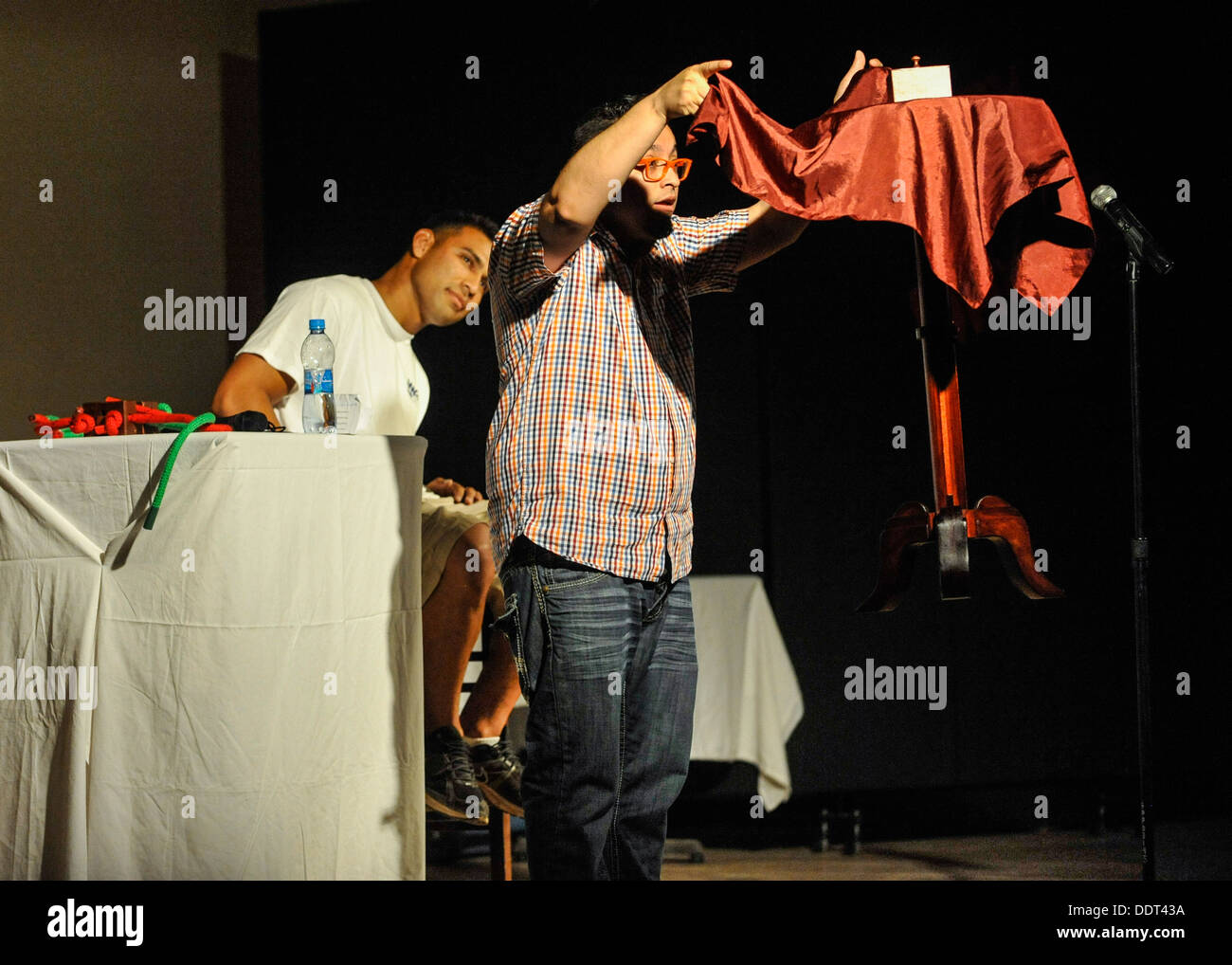 CAMP LEMONNIER, Gibuti (sett. 4, 2013) Comedic mago Wacko levita una tabella mentre un membro del pubblico guarda, durante il Foto Stock