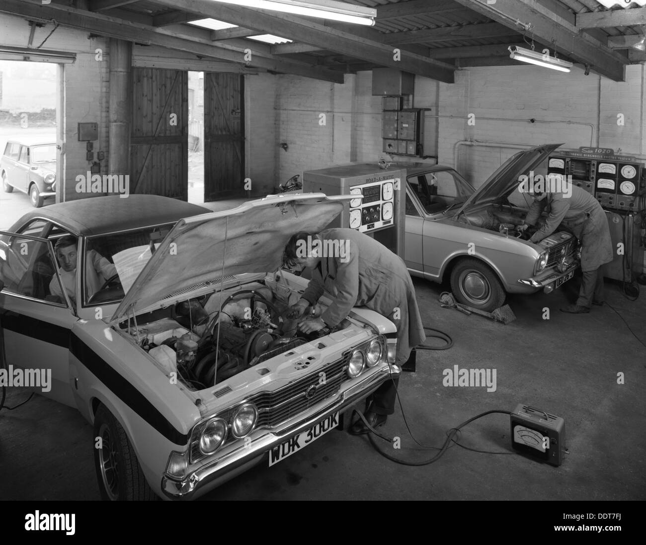 Cortina Mk 2 e Mk3 GT in un garage di essere serviti/modificato, 1972. Artista: Michael Walters Foto Stock