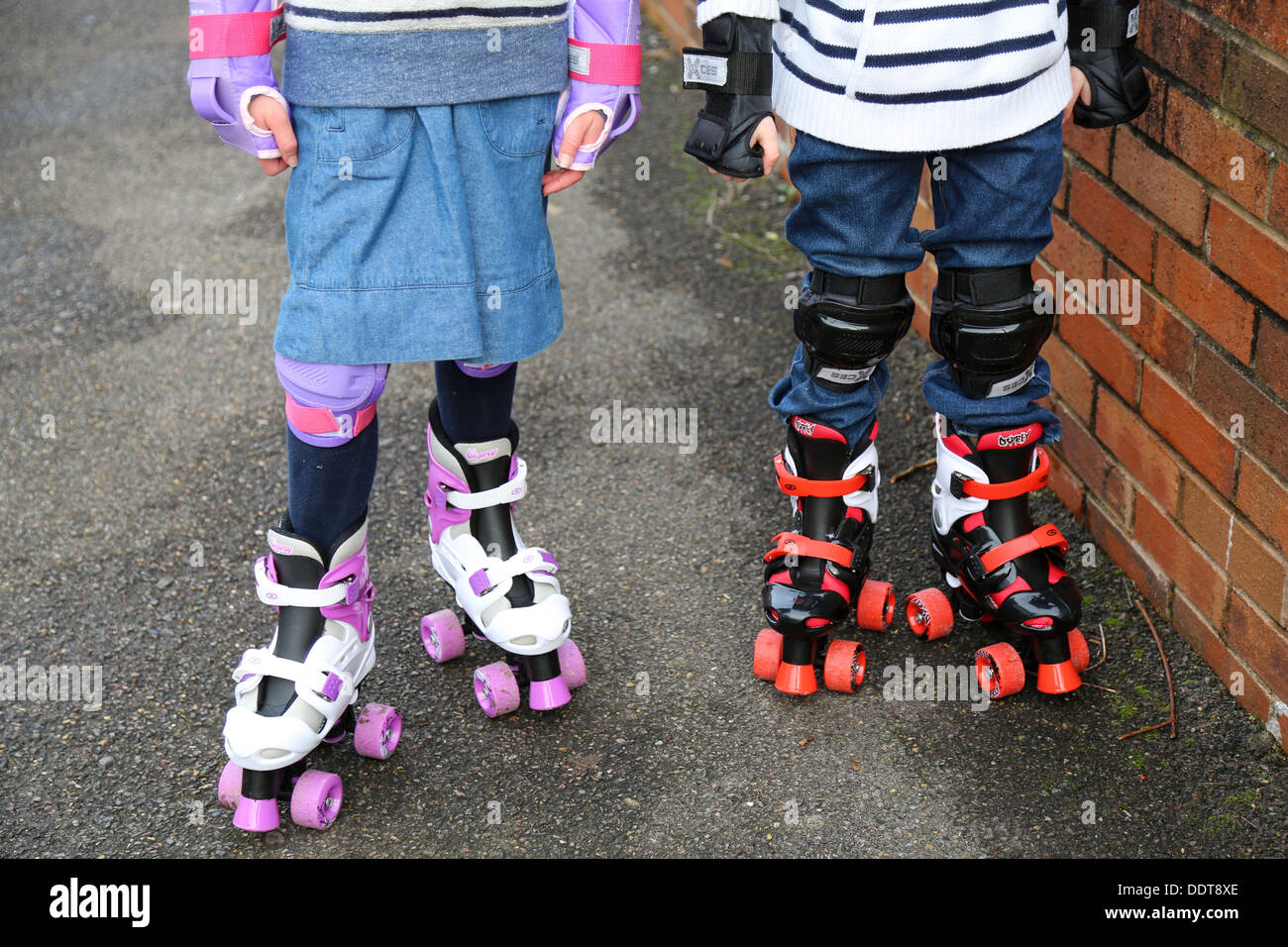Bambini indossare i pattini a rotelle Foto Stock