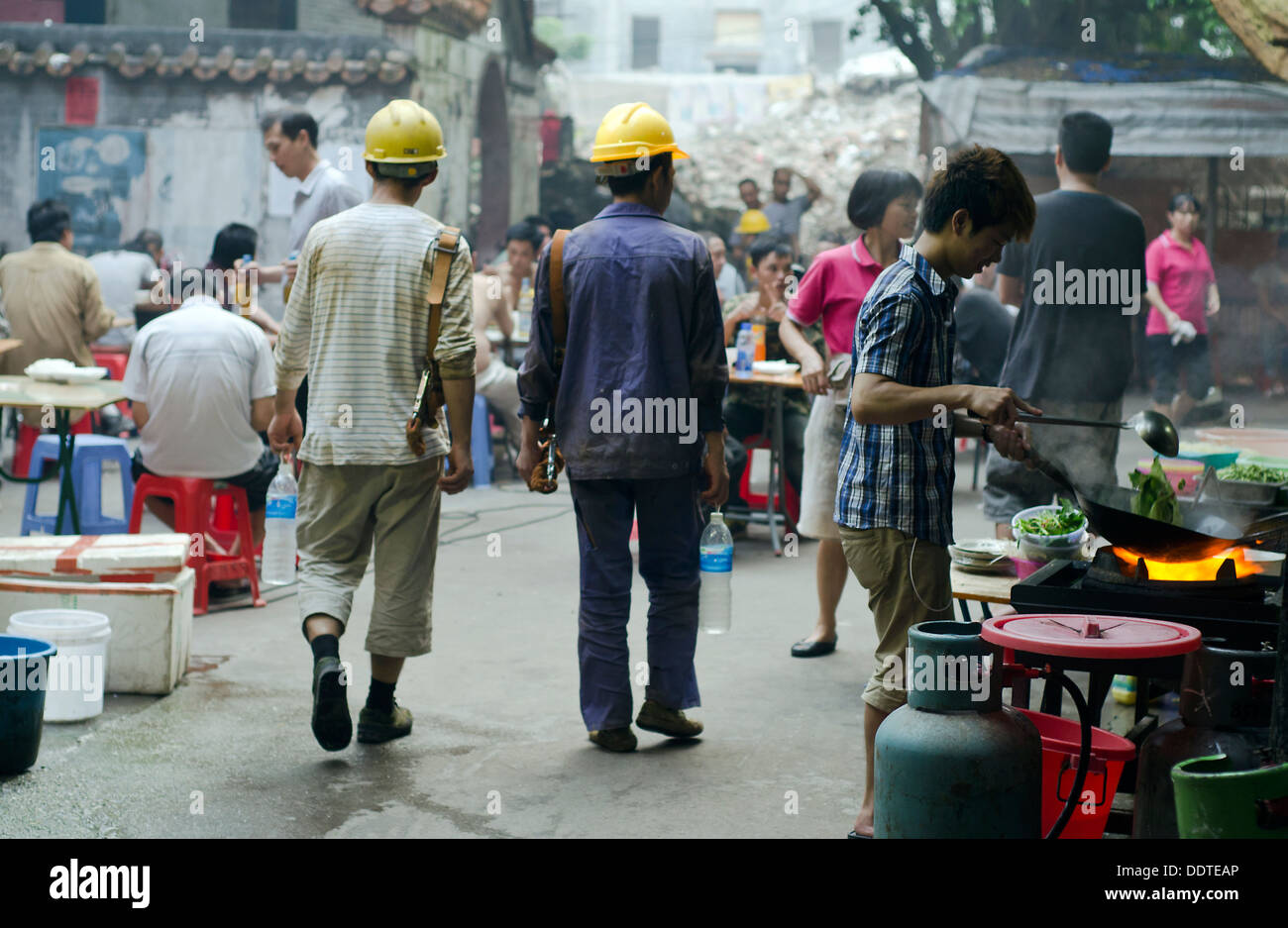 Costruzione cinese lavoratori passando per la strada di Xian Cun Village Guangzhou , Cina Foto Stock