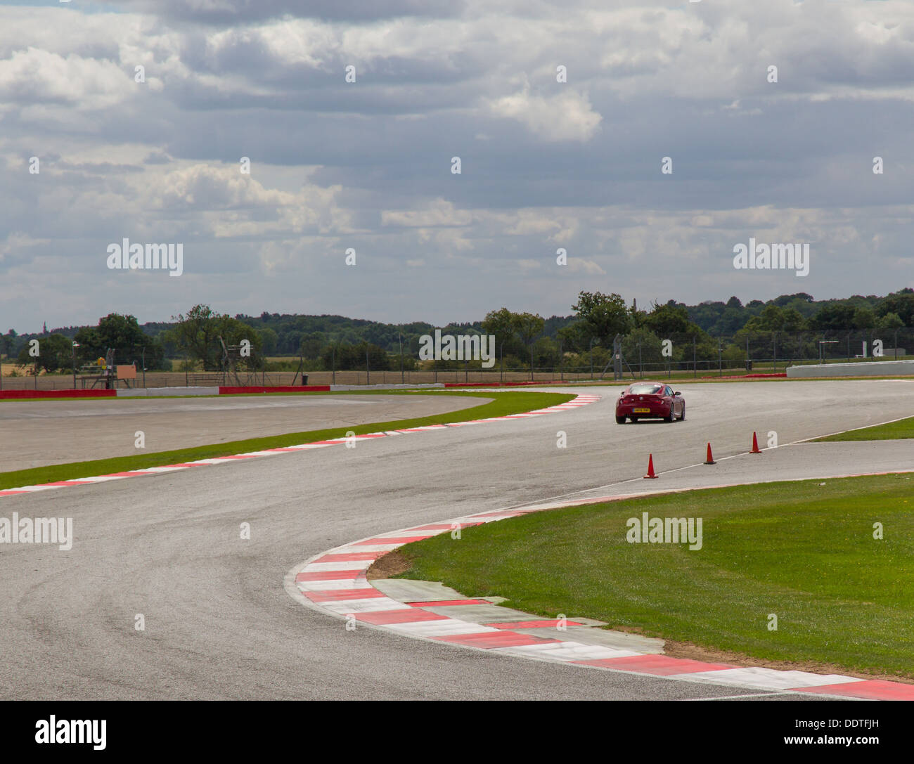 Una Ferrari andando attraverso Maggotts e angoli Becketts presso il circuito di Silverstone, Inghilterra. Foto Stock