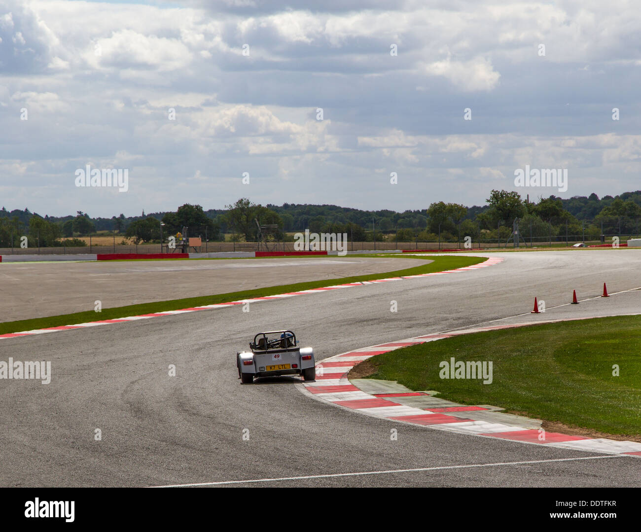 Una Caterham 7 attraversando Maggotts e angoli Becketts presso il circuito di Silverstone, Inghilterra. Foto Stock