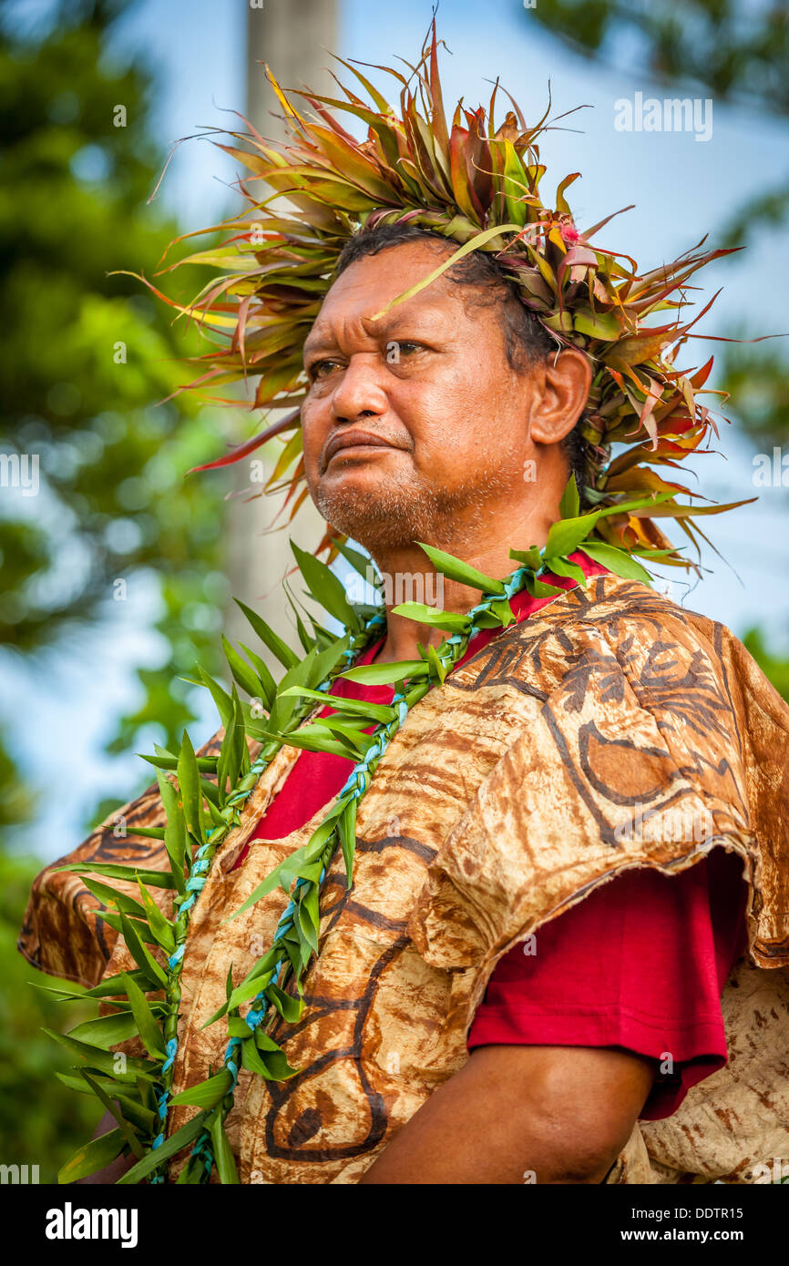 Un uomo vestito in tradizionale costume polinesiano partecipa ad una parata come parte dell'investitura di Makirau Haurua, Aitutaki Foto Stock