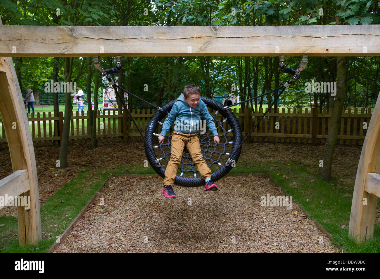 Giovane ragazzo giocando sulla Wilderness Area di gioco alla Corte Witley e giardini in Worcestershire. Foto Stock