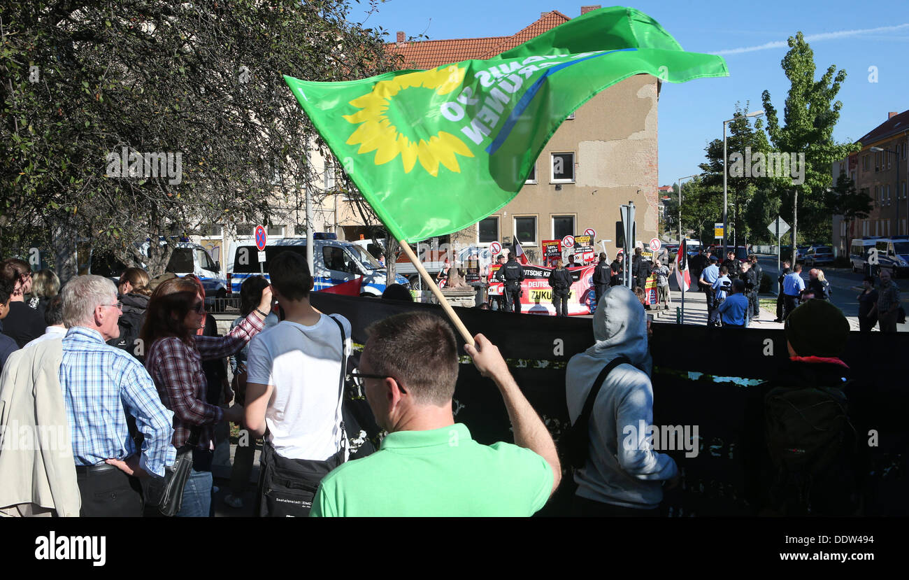 I membri di una azione di sinistra protesta di associazione con un flag di alleanza 90/Verdi nella parte anteriore di un richiedenti asilo home a Gera, Germania, 07 settembre 2013. Il partito di estrema destra NPD detiene un evento sotto il motto "giornata di azione contro l'asilo flood" vicino alla casa. Foto: BODO SCHACKOW Foto Stock