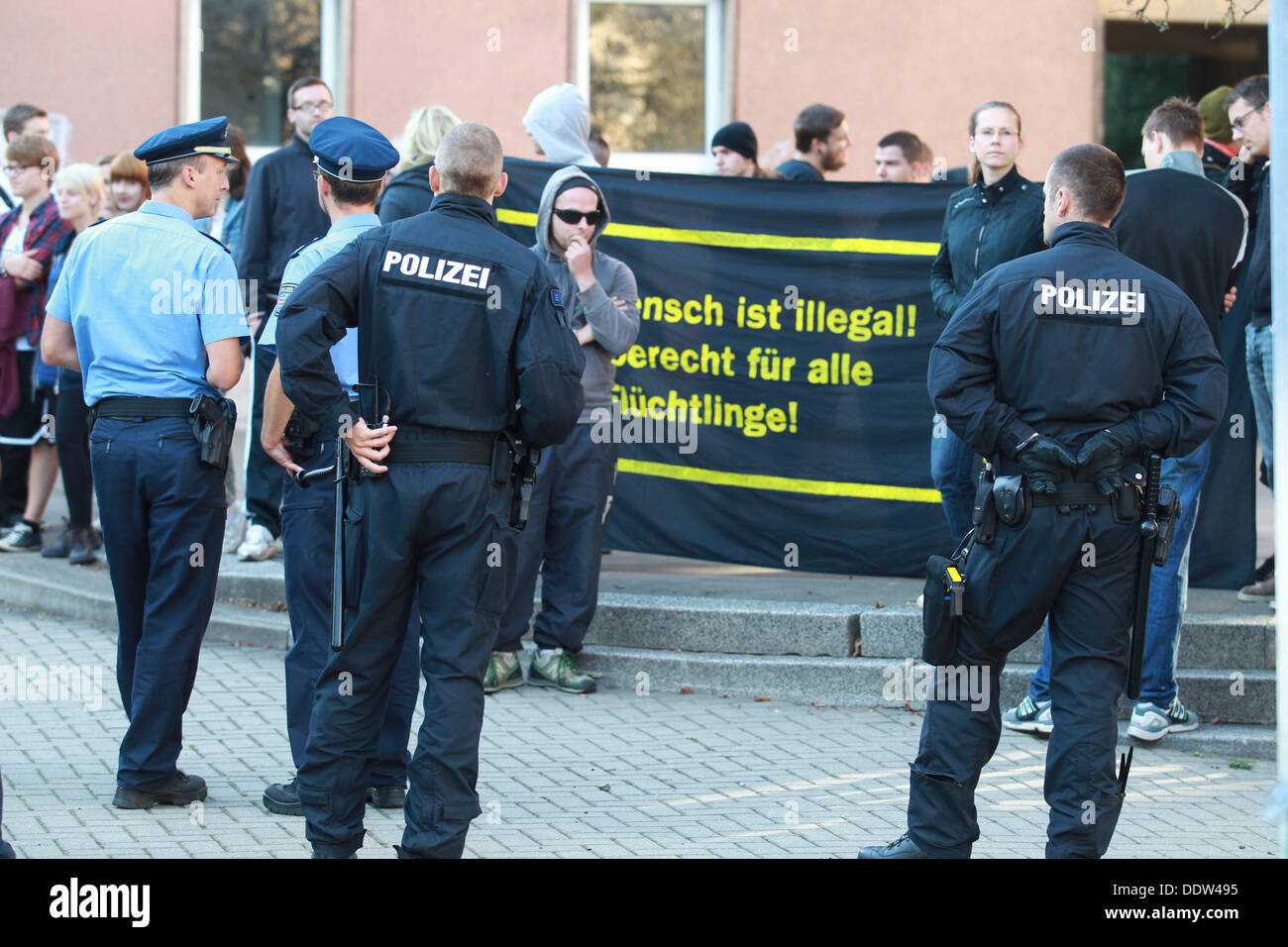 I membri di una sinistra action association e gli ufficiali di polizia a stare di fronte ad un i richiedenti asilo home a Gera, Germania, 07 settembre 2013. Il partito di estrema destra NPD detiene un evento sotto il motto "giornata di azione contro l'asilo flood" vicino alla casa. Foto: BODO SCHACKOW Foto Stock