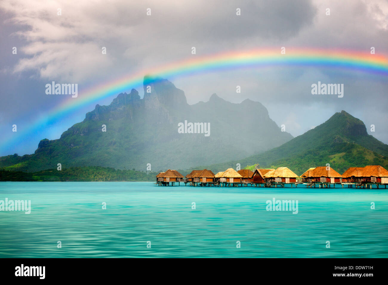 Bungalows sull'acqua con arcobaleno e Mt. Otemanu. Bora Bora. Polinesia francese Foto Stock