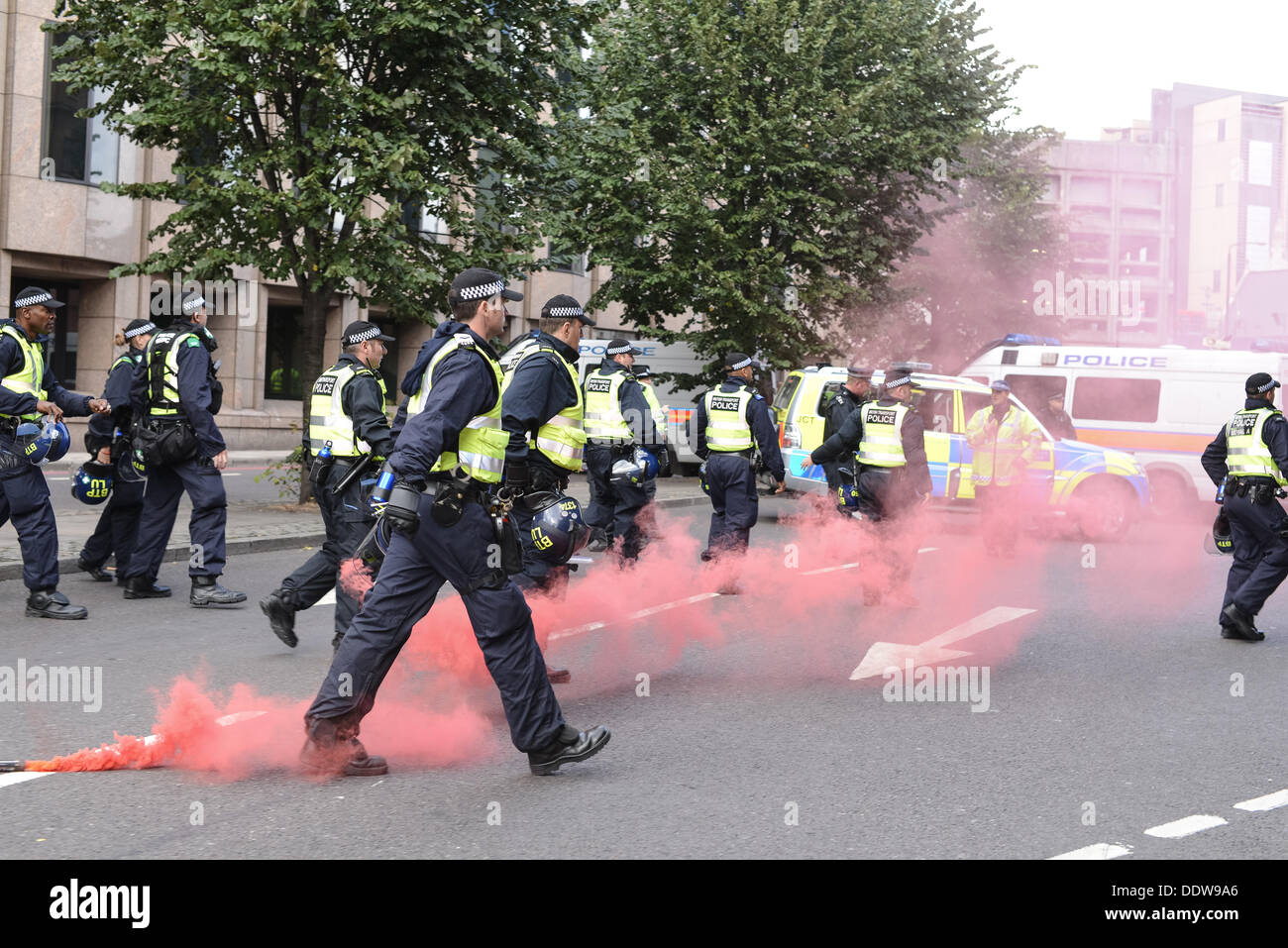 Londra, Regno Unito. 07Th Sep, 2013. La Polizia risponde al fumo bombe lanciate da Black Bloc anti-EDL manifestanti tentano di rompere le linee di polizia, presso il Tower Bridge. Centinaia di EDL manifestanti hanno marciato attraverso il Tower Bridge alla stazione di Aldgate, con relativamente poca violenza. Credito: fotografia tinite/Alamy Live News Foto Stock