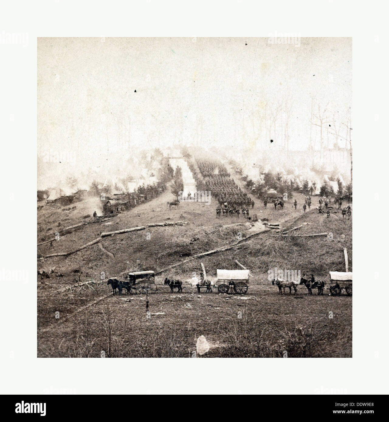 La guerra civile americana: tre a cavalli in carri coperti in primo piano. Soldati che marciano in formazione Foto Stock
