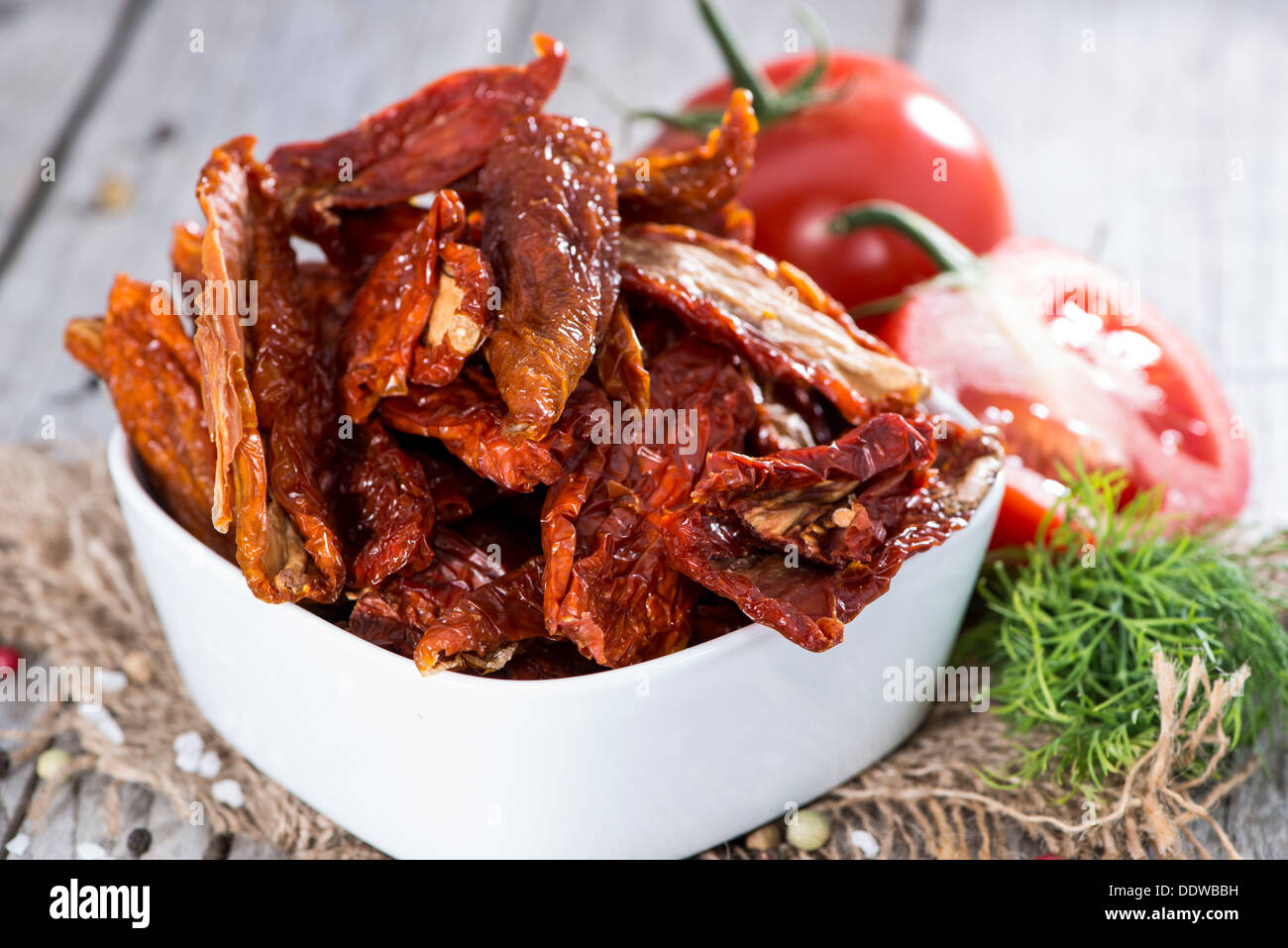 Porzione di pomodori seccati al sole su sfondo di legno Foto Stock