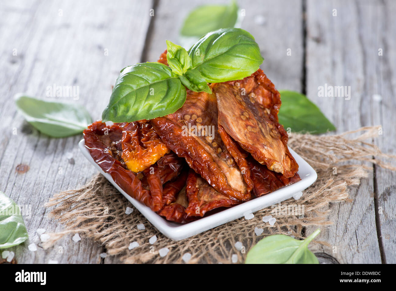 Porzione di pomodori seccati al sole su sfondo di legno Foto Stock