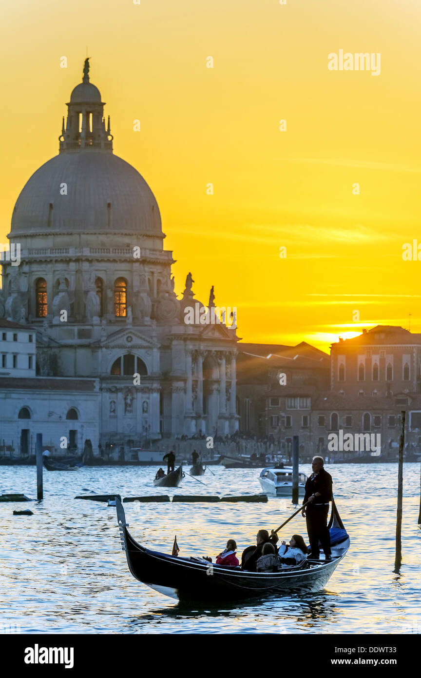 L'Europa, Italia, Veneto, Venezia, classificato come patrimonio mondiale dall'UNESCO. Gondola di fronte alla Madonna della Salute al tramonto. Foto Stock
