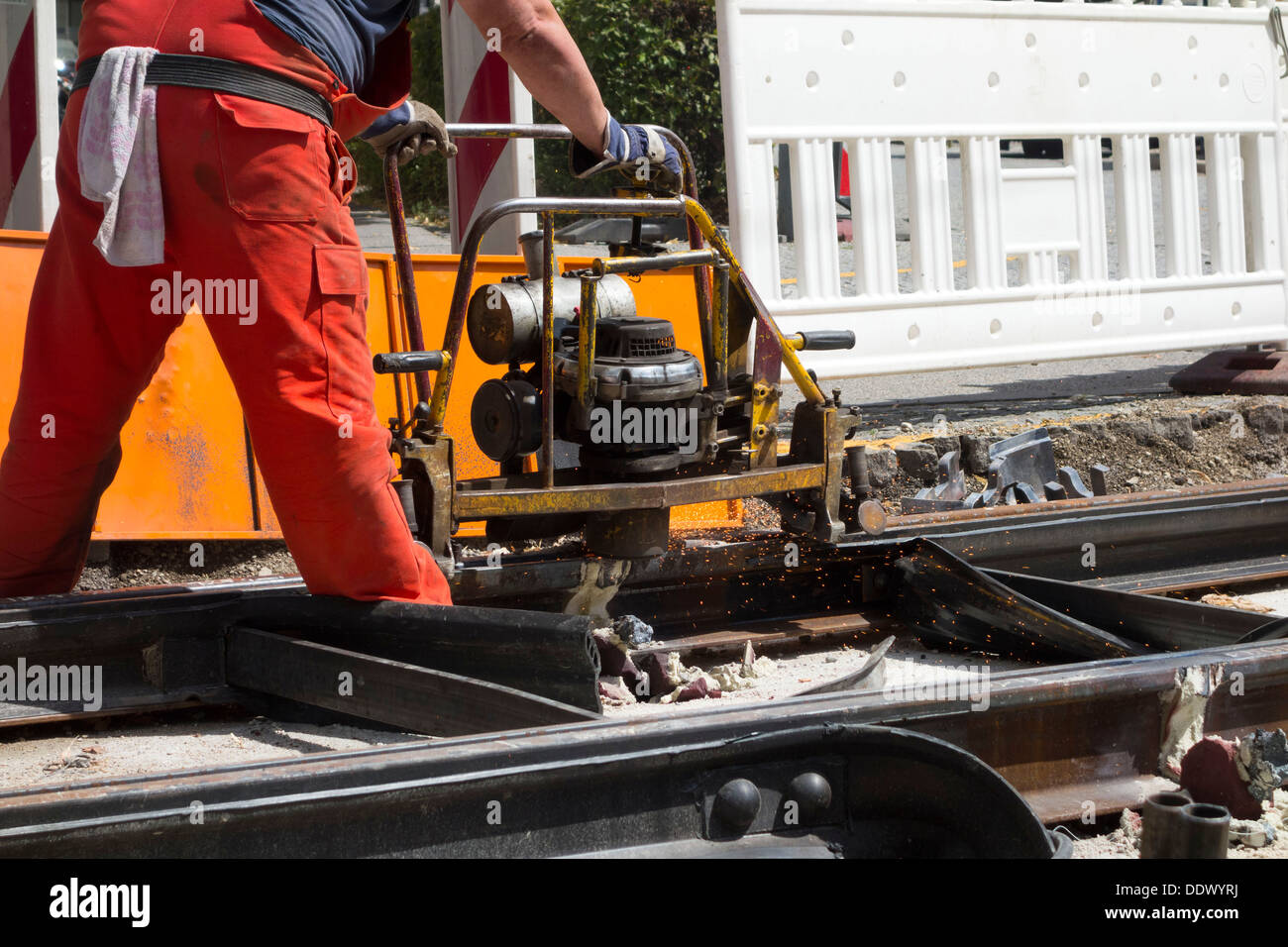 Uomo Macchina la macinazione di una linea di tram dopo essendo saldato, Monaco di Baviera Baviera Germania Foto Stock