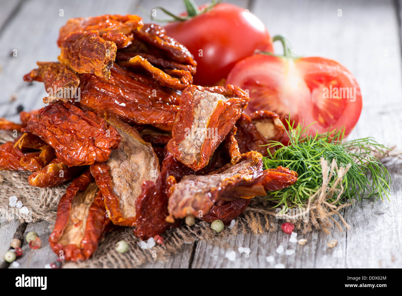 Porzione di secchi e salati pomodori su sfondo di legno Foto Stock
