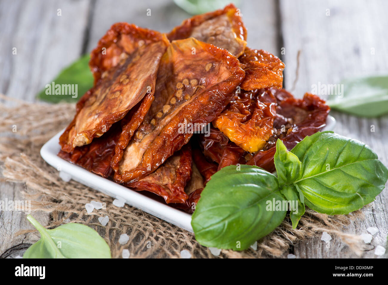 Porzione di secchi e salati pomodori su sfondo di legno Foto Stock