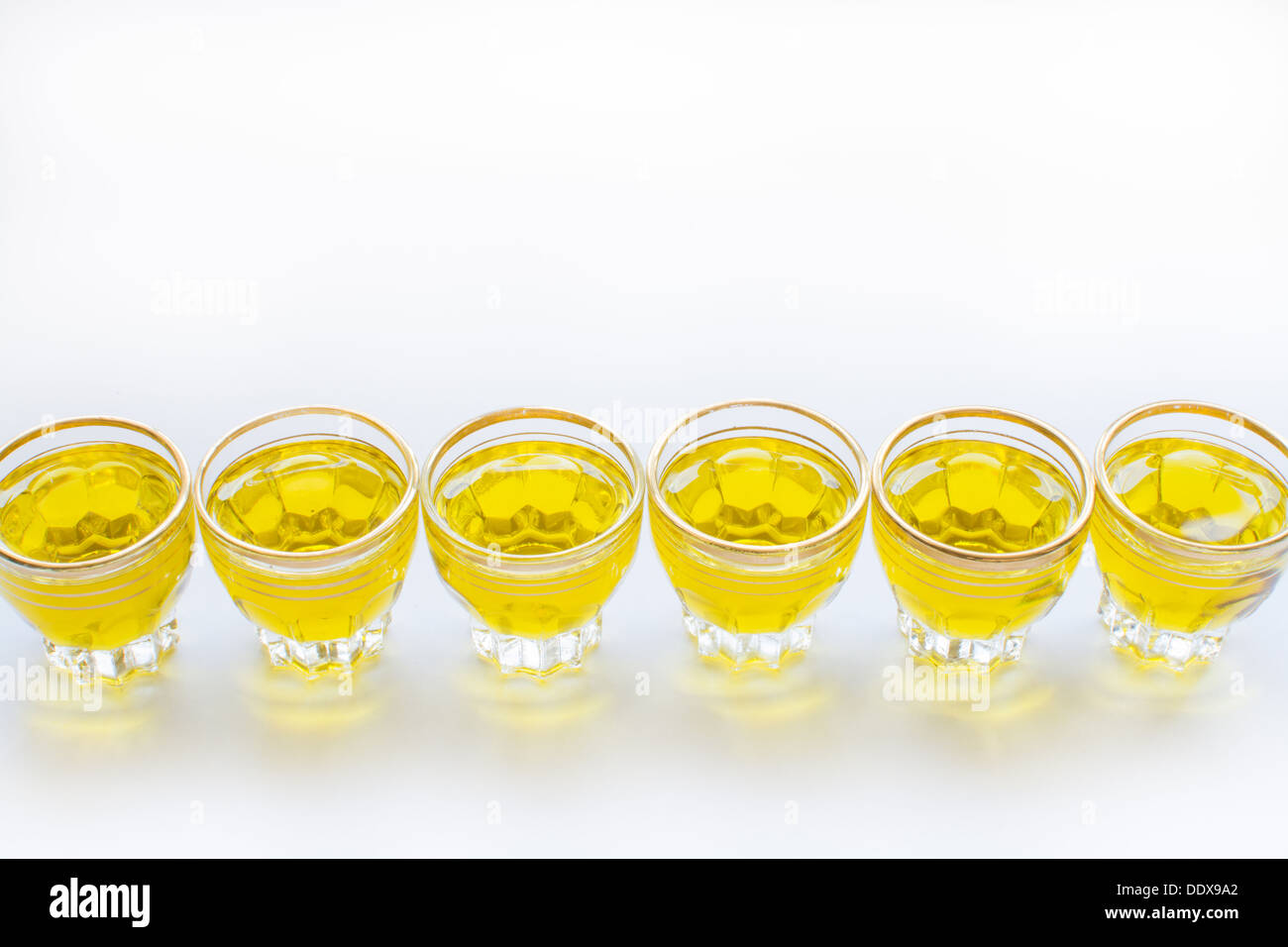 Sei piccoli bicchierini di fila con golden olio d'oliva e copia in bianco lo spazio. Foto Stock