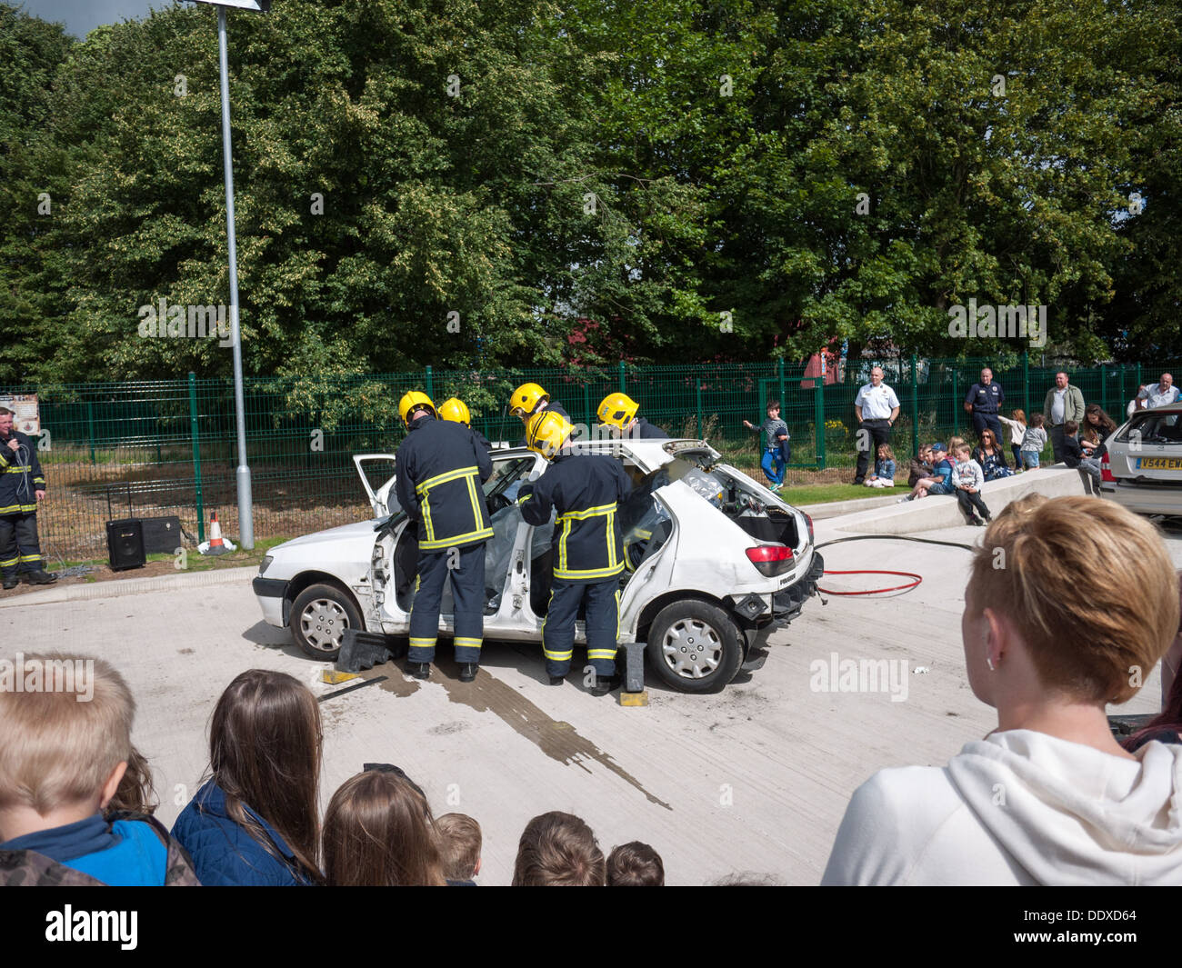 Fire crew dimostrando il taglio di un tetto auto nella simulazione di salvataggio in corrispondenza di una stazione di fuoco open day Foto Stock