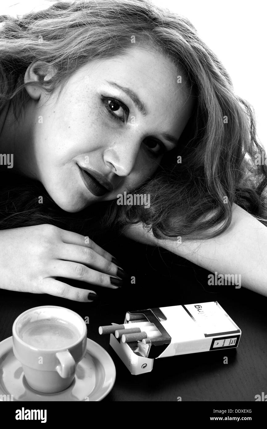 Giovane Donna con capelli rossi, rilassante con un caffè espresso e sigarette al mattino forte, isolato su bianco Foto Stock