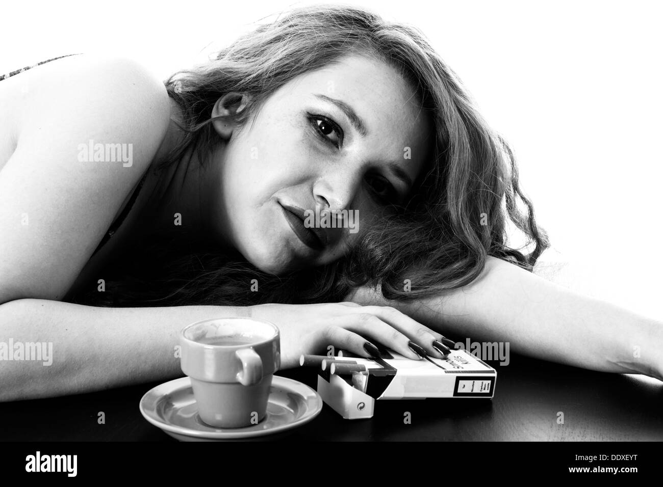 Giovane Donna con capelli rossi, rilassante con un caffè espresso e sigarette al mattino forte, isolato su bianco Foto Stock