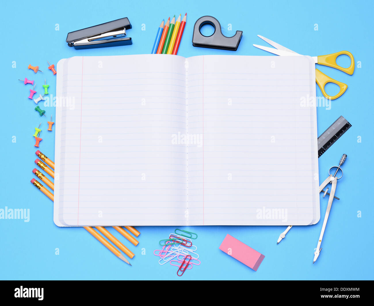 Un notebook aperto circondato da forniture scolastiche. Si torna a scuola concetto. Foto Stock