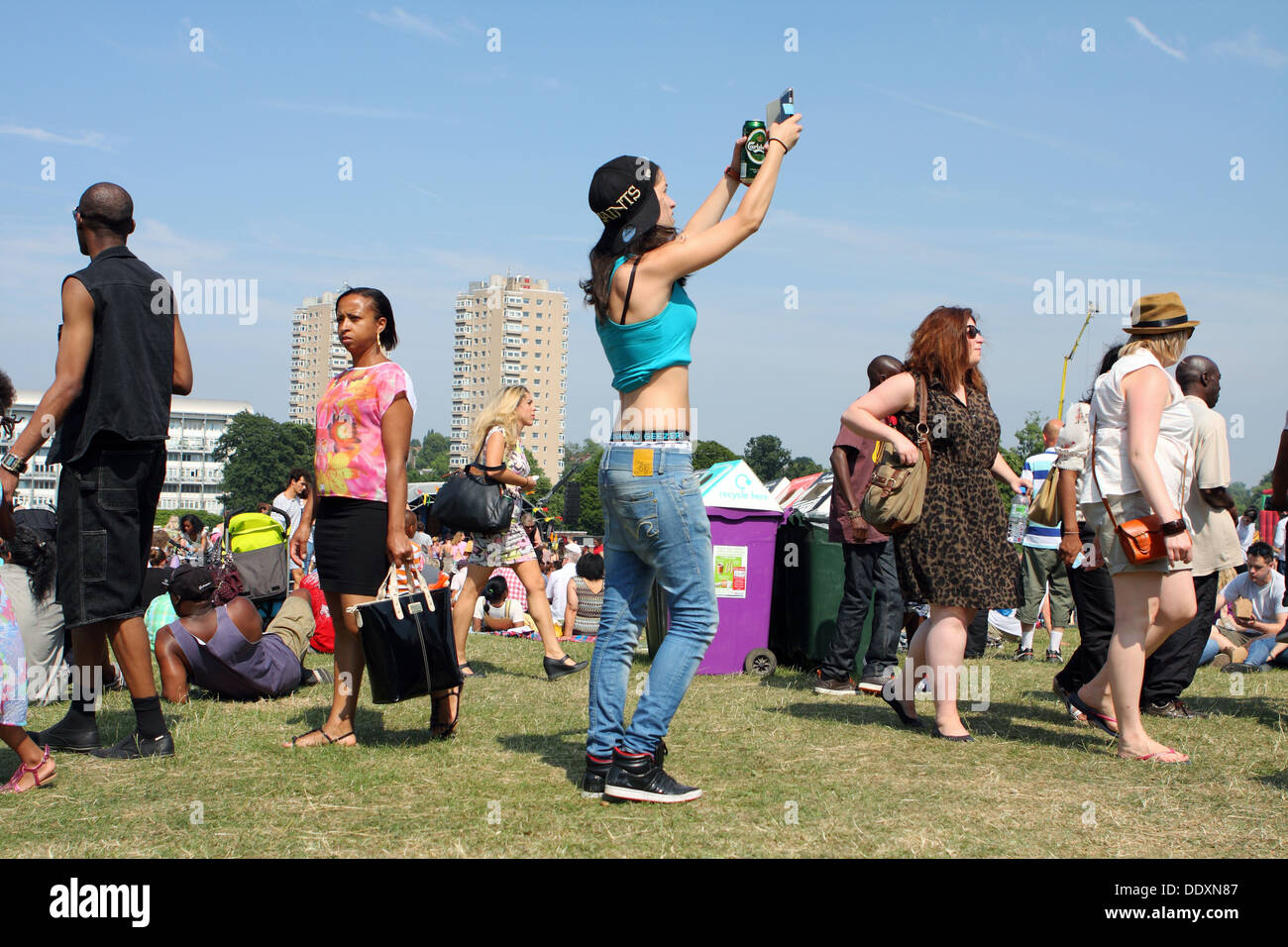 Una femmina di scattare fotografie a Lambeth Festival, Brockwell Park, Londra - estate 2013 Foto Stock