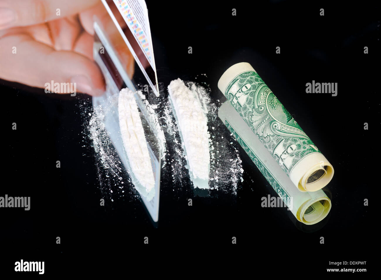 La cocaina e il denaro nero su sfondo a specchio Foto Stock