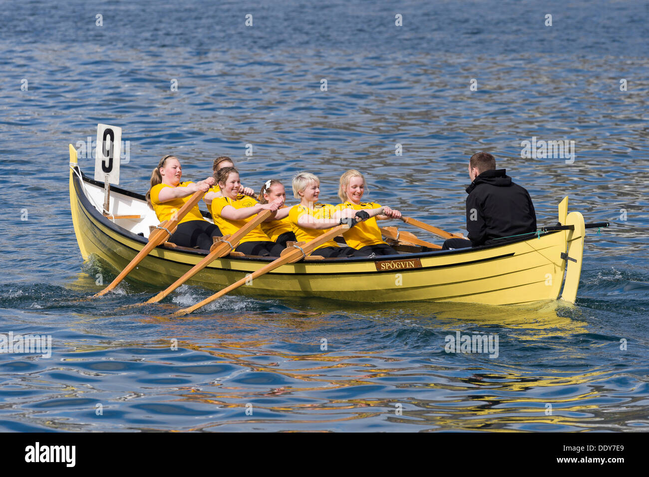Giallo barca a remi, presidiata da una donne squadra Foto Stock