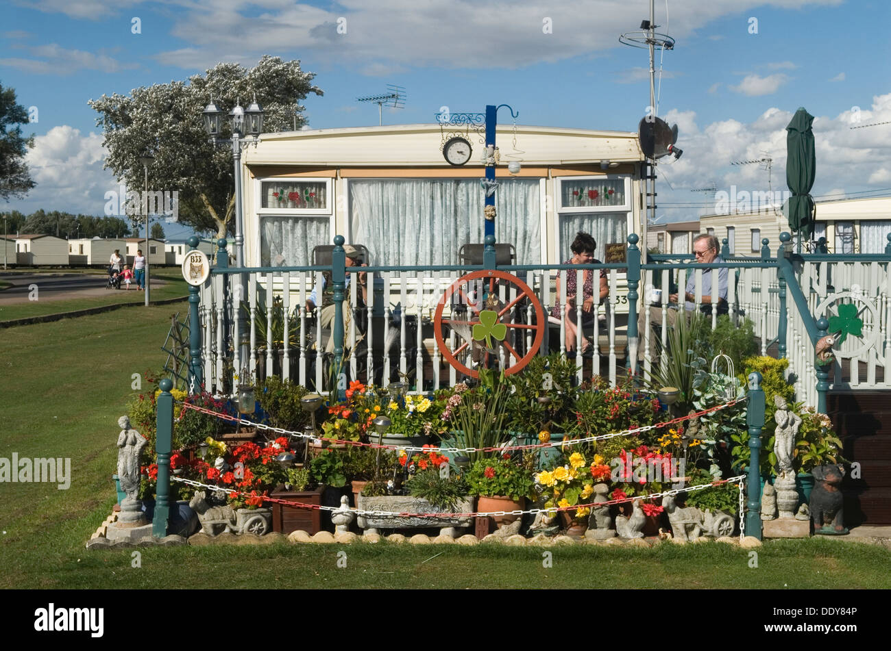 Caravan statico case vacanza chalet, campeggio permanente St Osyth Essex Regno Unito. Famiglia nel giardino di fronte al St Osyth Beach Holiday Home Park. Settembre 2013 2010 HOMER SYKES Foto Stock